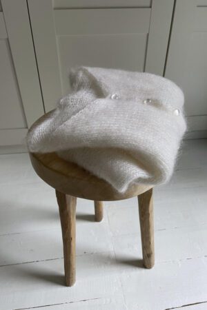 v-neckline ivory mohair sweater folded on a chair